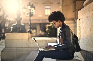 A woman is focusing on her work outside the building